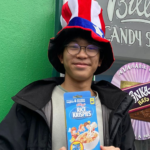 Young boy wearing a patriotic hat holding a box of Rice Krispies cereal.