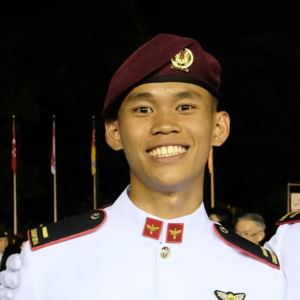 Young military officer in uniform smiling at night.
