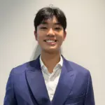 Young man in blue suit smiling for the camera.