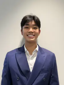 Young man in blue suit smiling for the camera.