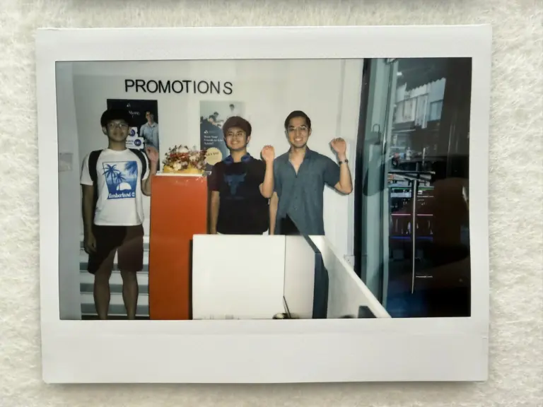 Three students celebrating success at Axiom Education promotions event.