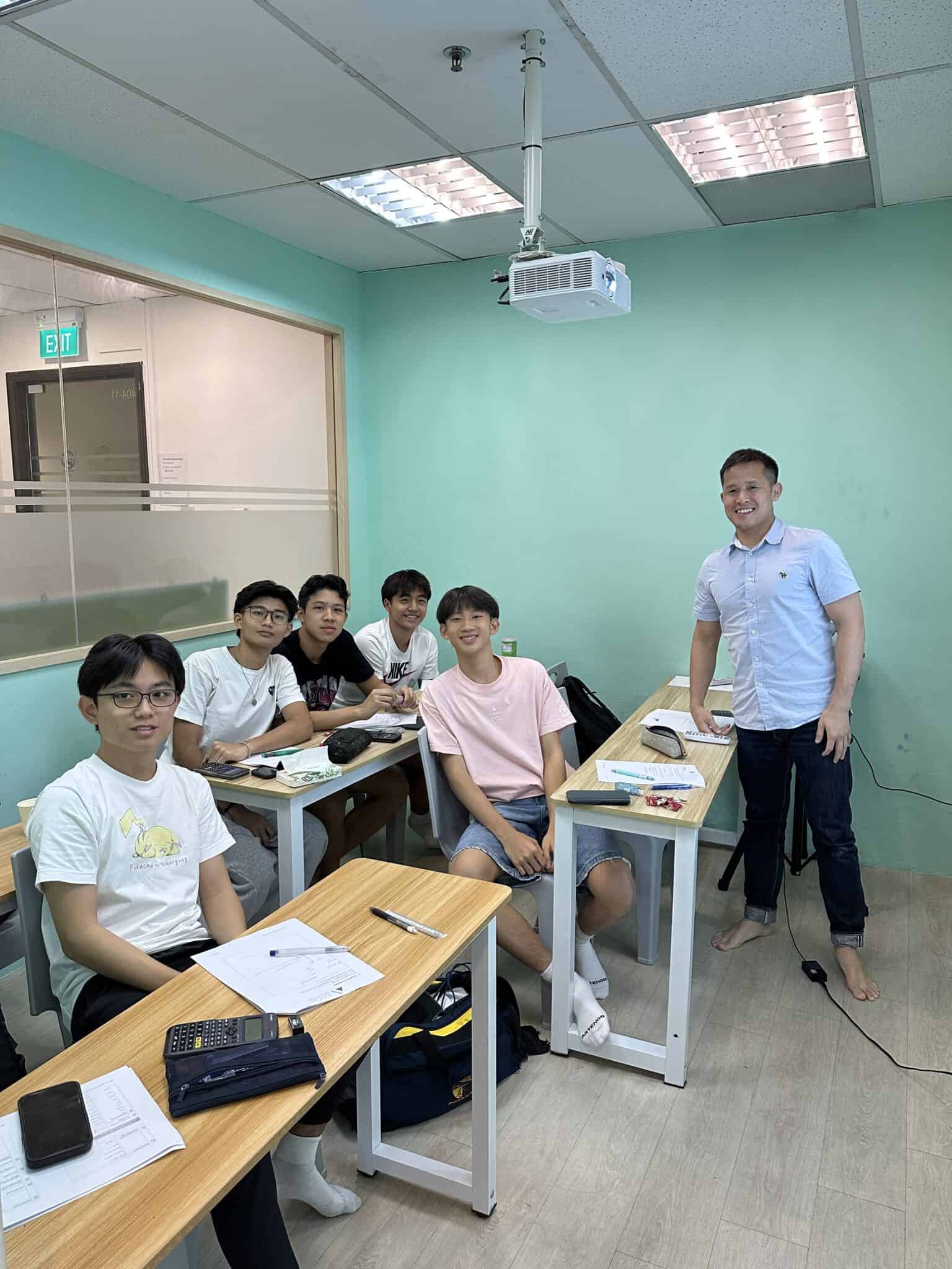 Secondary school students in a classroom with teacher at Axiom Education.