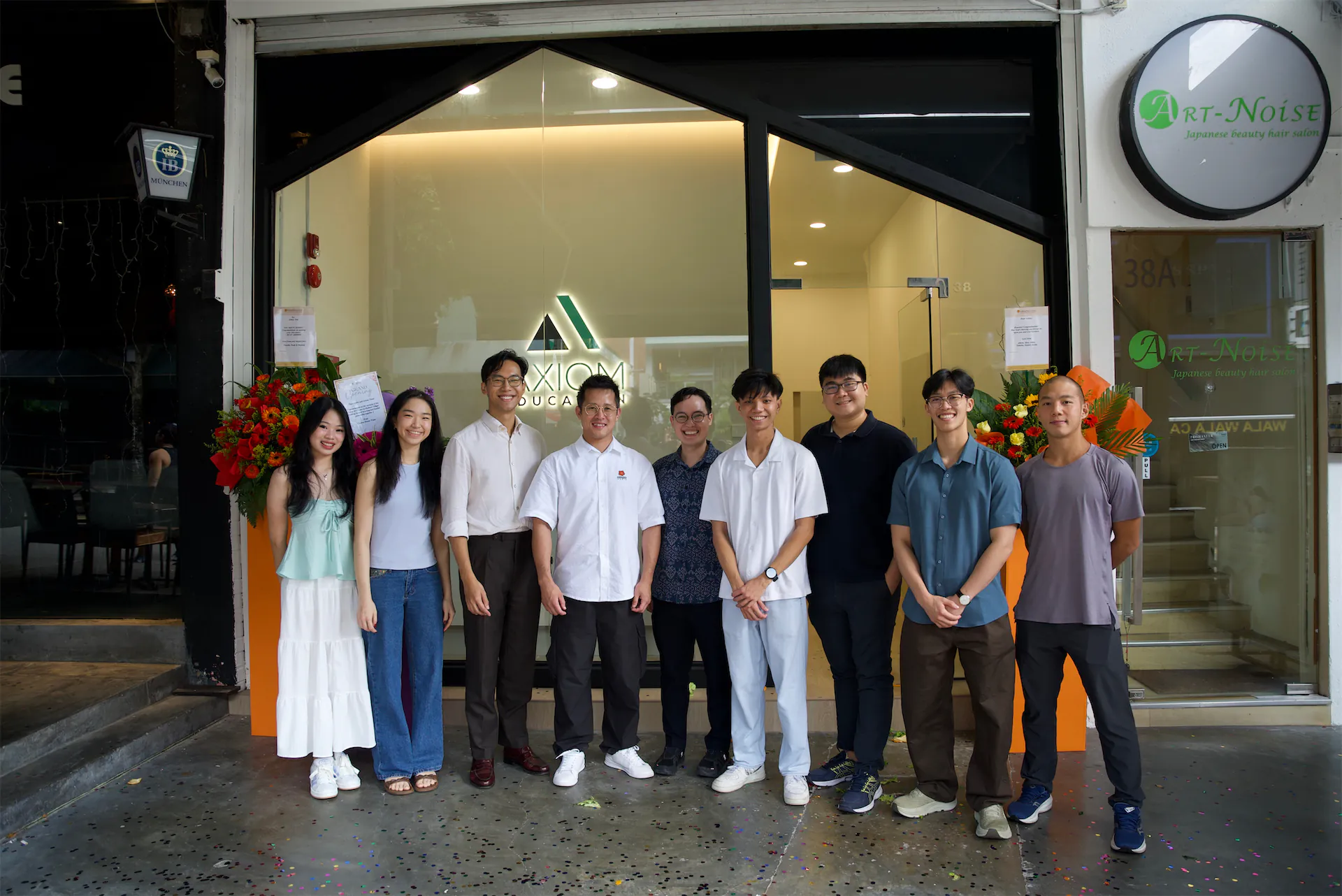 Group of students and instructor standing outside Axiom Education building.