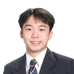 Young man in formal suit smiling for professional portrait.